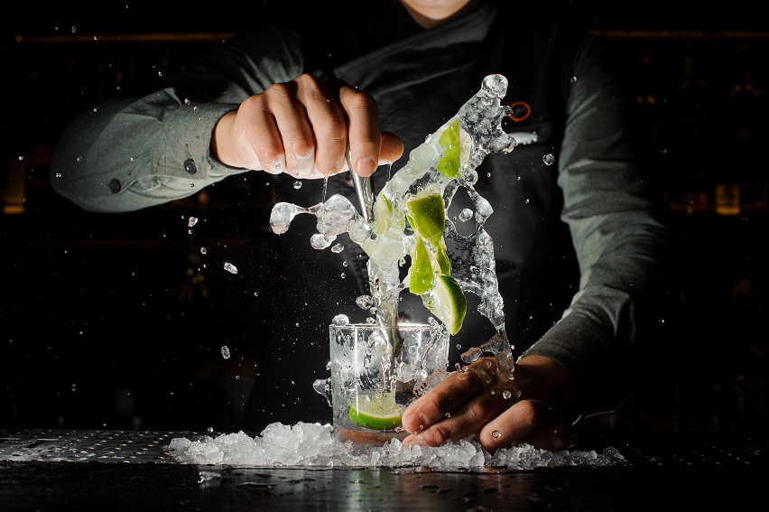 Barman,Hand,Squeezing,Fresh,Juice,From,Lime,In,The,Glass